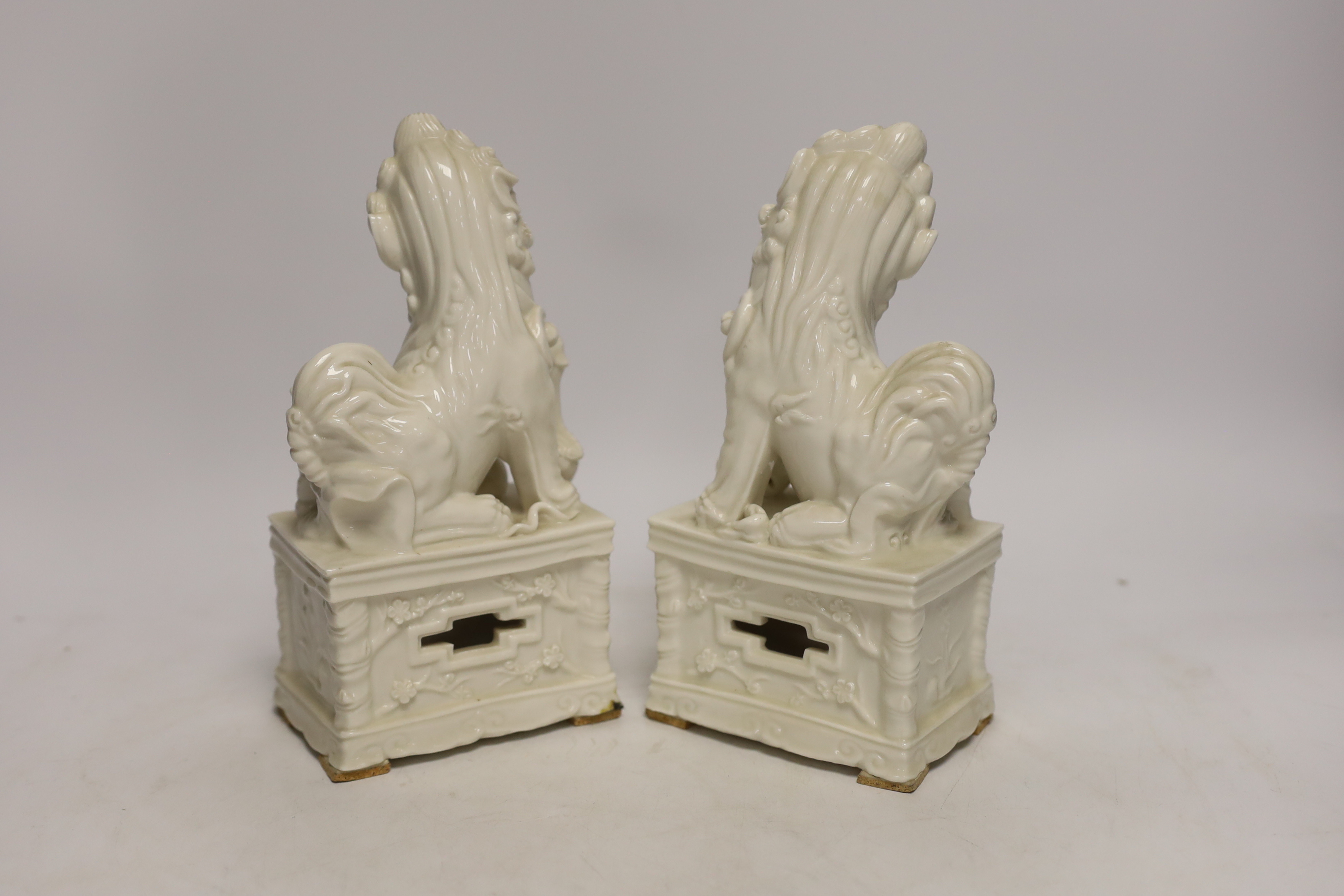 A pair of Chinese blanc de chine lion dogs, 21cm high